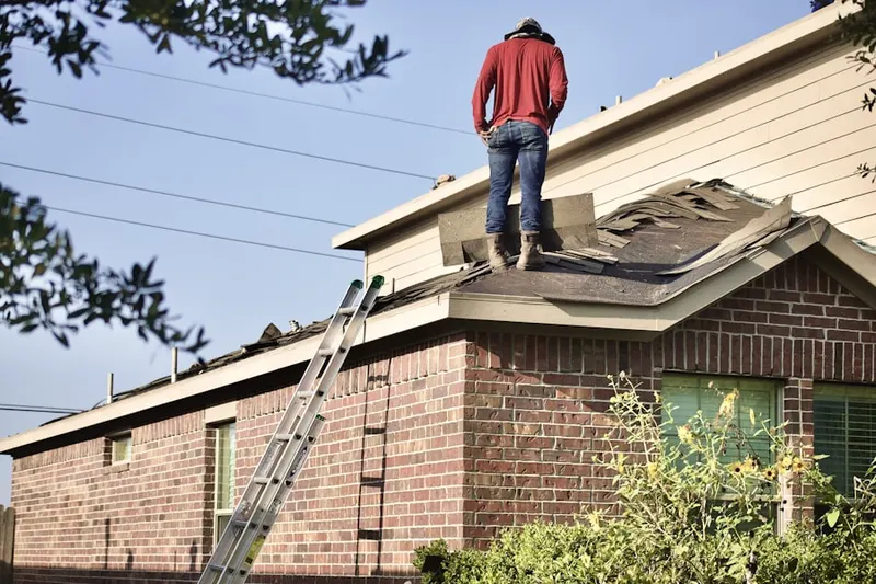 Professional roofer working on a residential roof in Millbury
